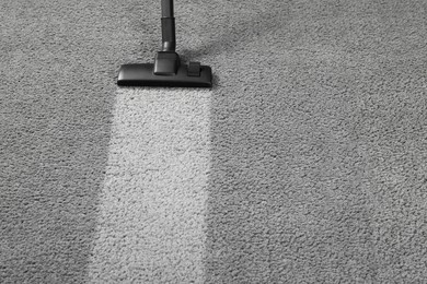 Vacuuming grey carpet. Clean area after using device. Space for text