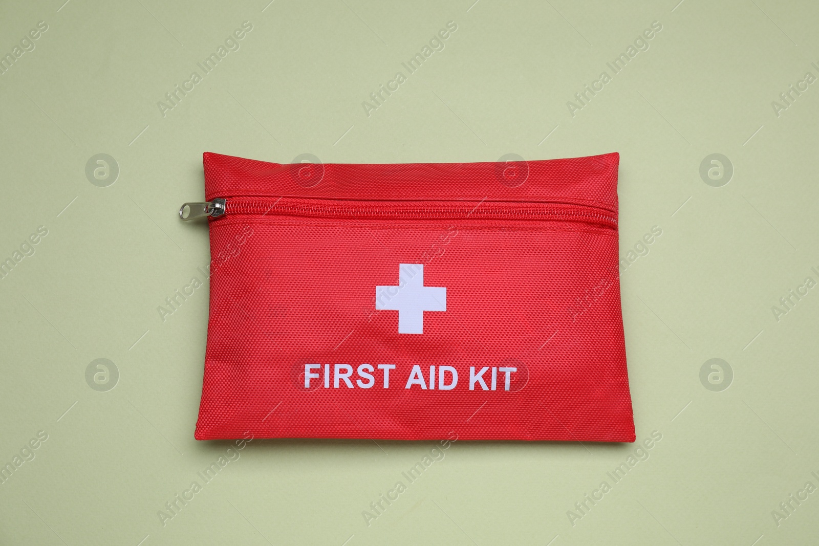 Photo of First aid kit on light green background, top view