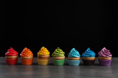 Delicious birthday cupcake on table against black background