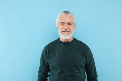 Photo of Portrait of handsome senior man on light blue background