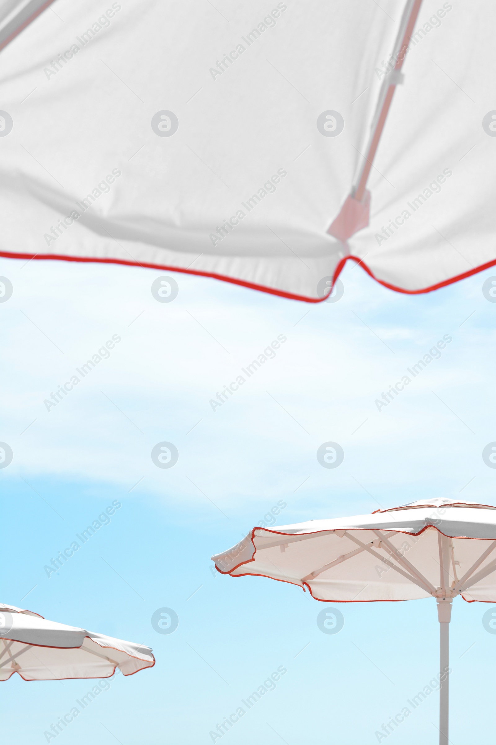 Photo of White beach umbrellas outdoors on sunny day