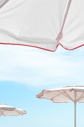 Photo of White beach umbrellas outdoors on sunny day