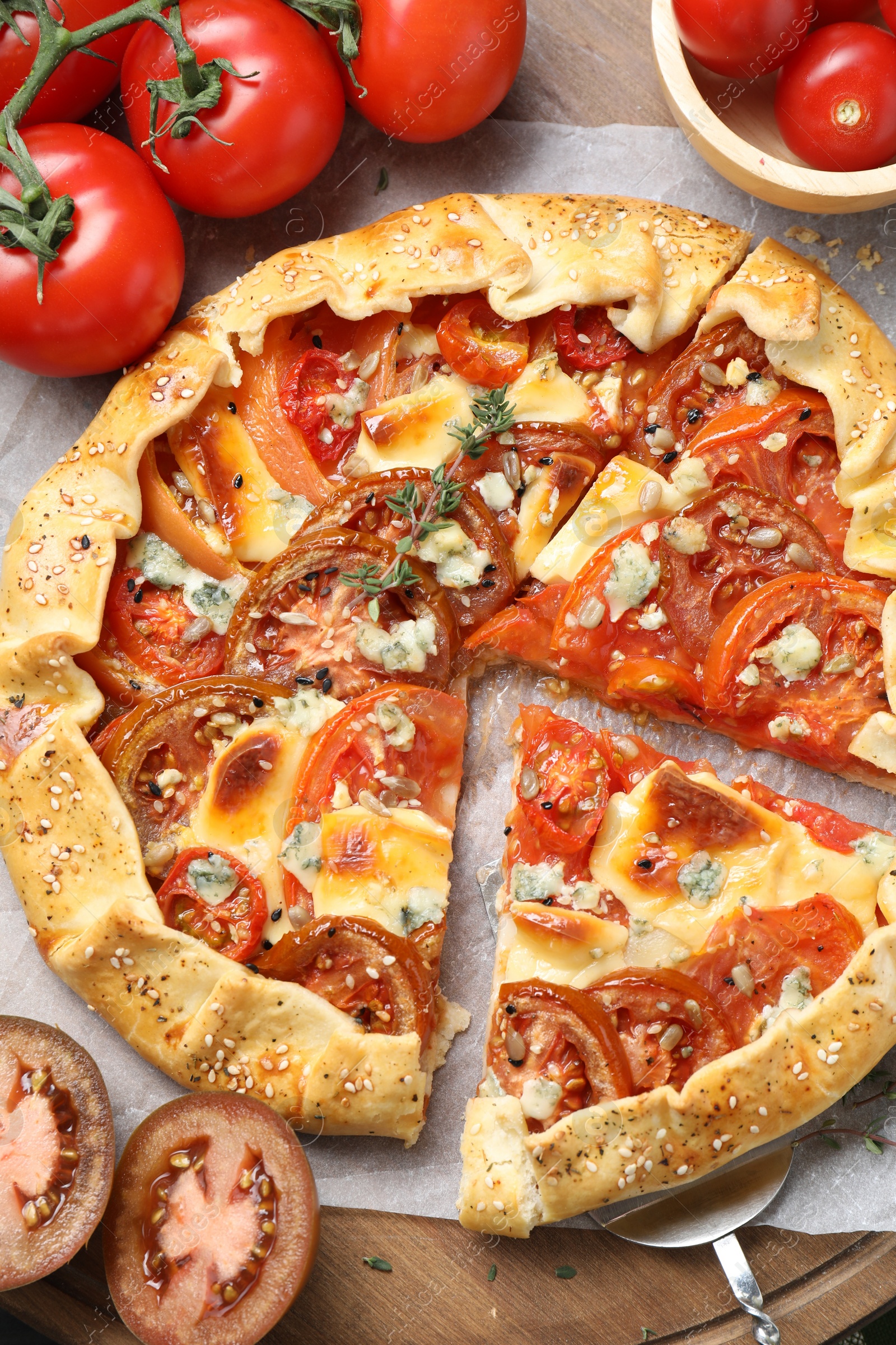 Photo of Tasty galette with tomato and cheese (Caprese galette) on wooden table, top view