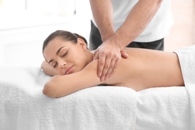 Relaxed woman receiving back massage in wellness center