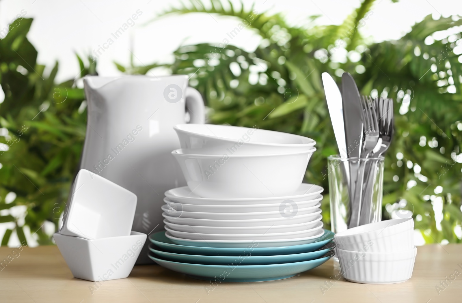 Photo of Set of clean dishes on blurred background