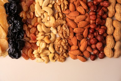 Photo of Mix of delicious dried nuts and fruits on beige background, flat lay