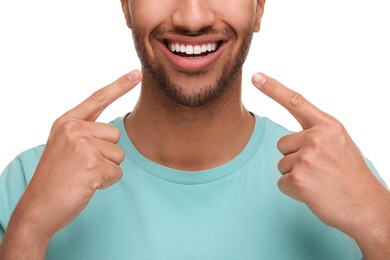 Photo of Man pointing at his healthy clean teeth on white background, closeup