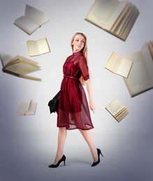 Young stylish woman in dress and flying books on light background