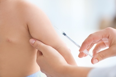 Photo of Doctor vaccinating baby in clinic, closeup