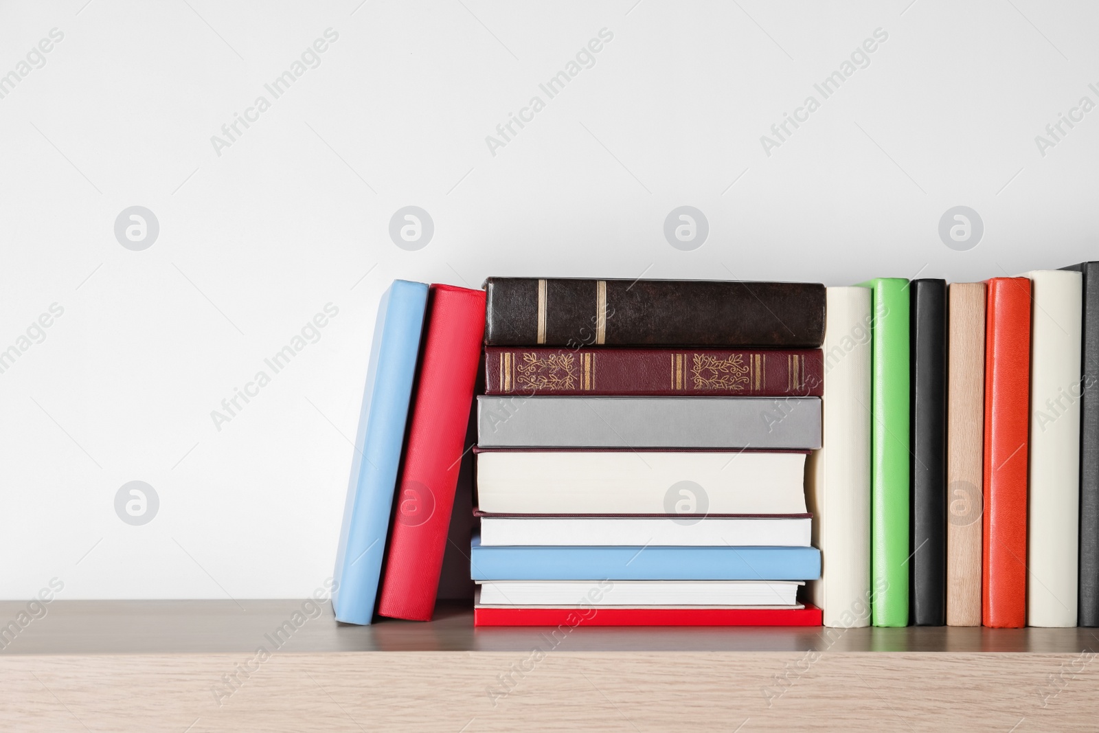 Photo of Different books on wooden table, space for text