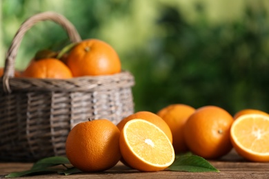 Fresh ripe oranges on wooden table against blurred background. Space for text