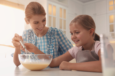 Mother and daughter making dough together in kitchen