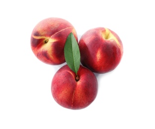 Sweet juicy peaches with leaf on white background, top view