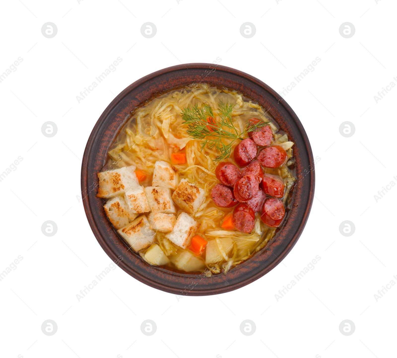 Photo of Bowl of delicious sauerkraut soup with smoked sausages, dill and croutons isolated on white, top view