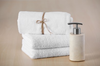 Soft towels and dispenser on wooden table