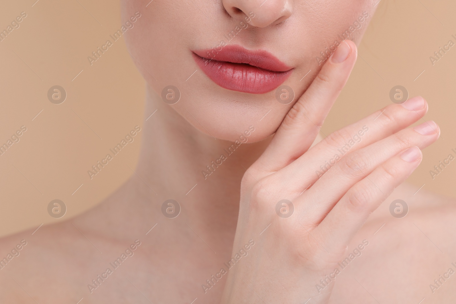 Photo of Young woman with beautiful full lips on beige background, closeup