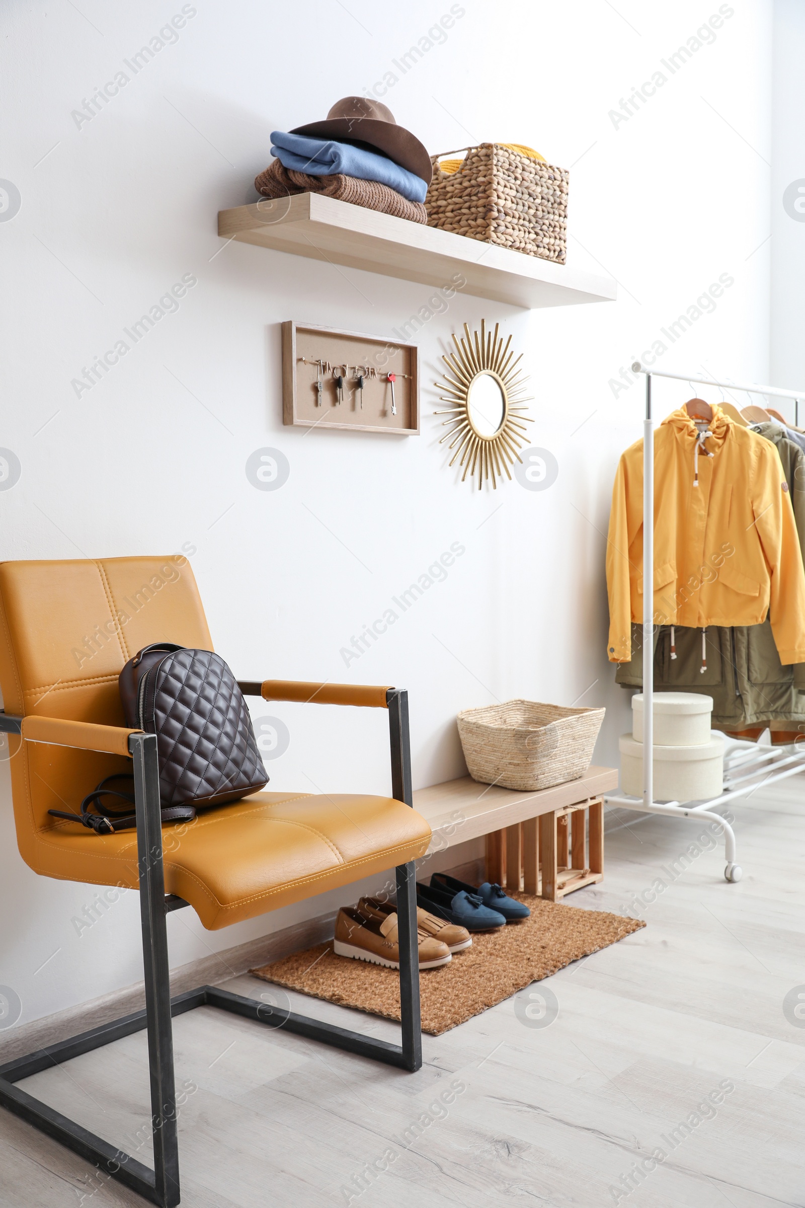Photo of Hallway interior with stylish furniture, clothes and accessories
