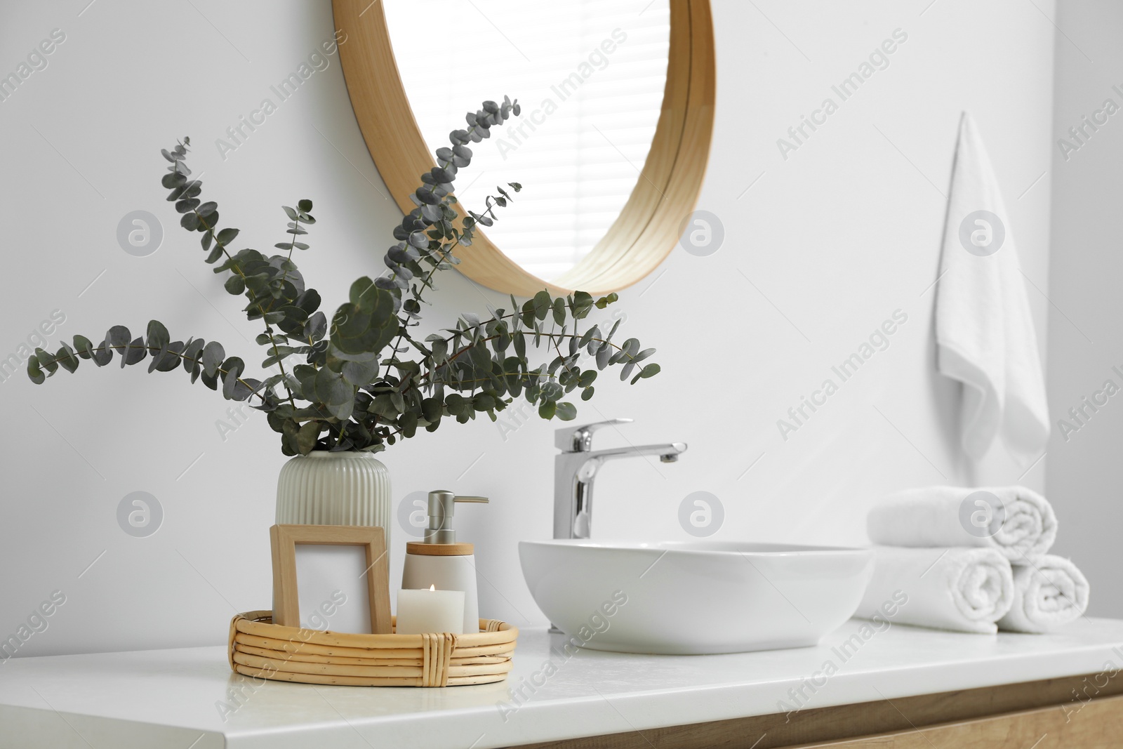 Photo of Vase with eucalyptus branches and toiletries near vessel sink in bathroom, space for text. Interior design