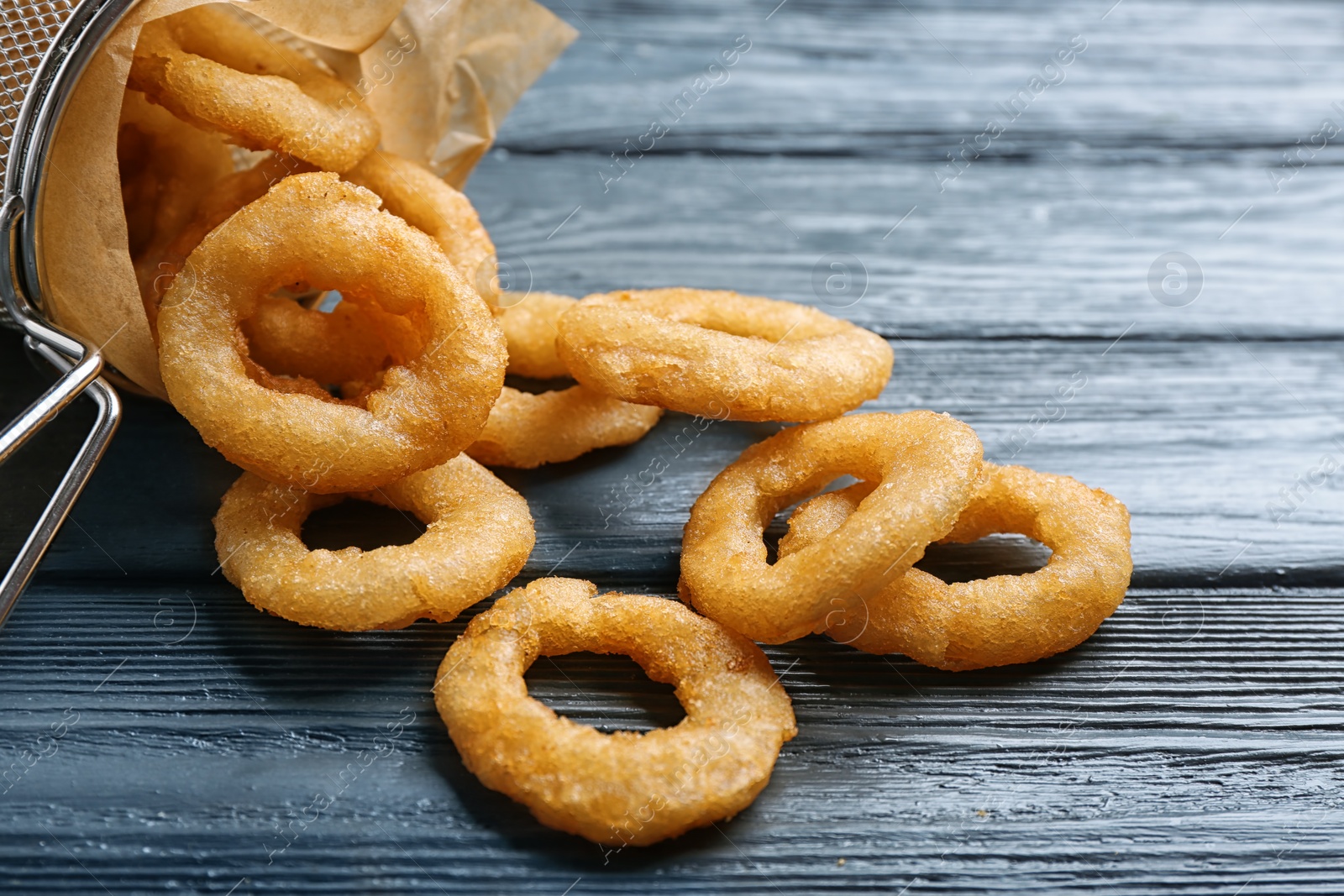 Photo of Onion rings served on wooden table, closeup