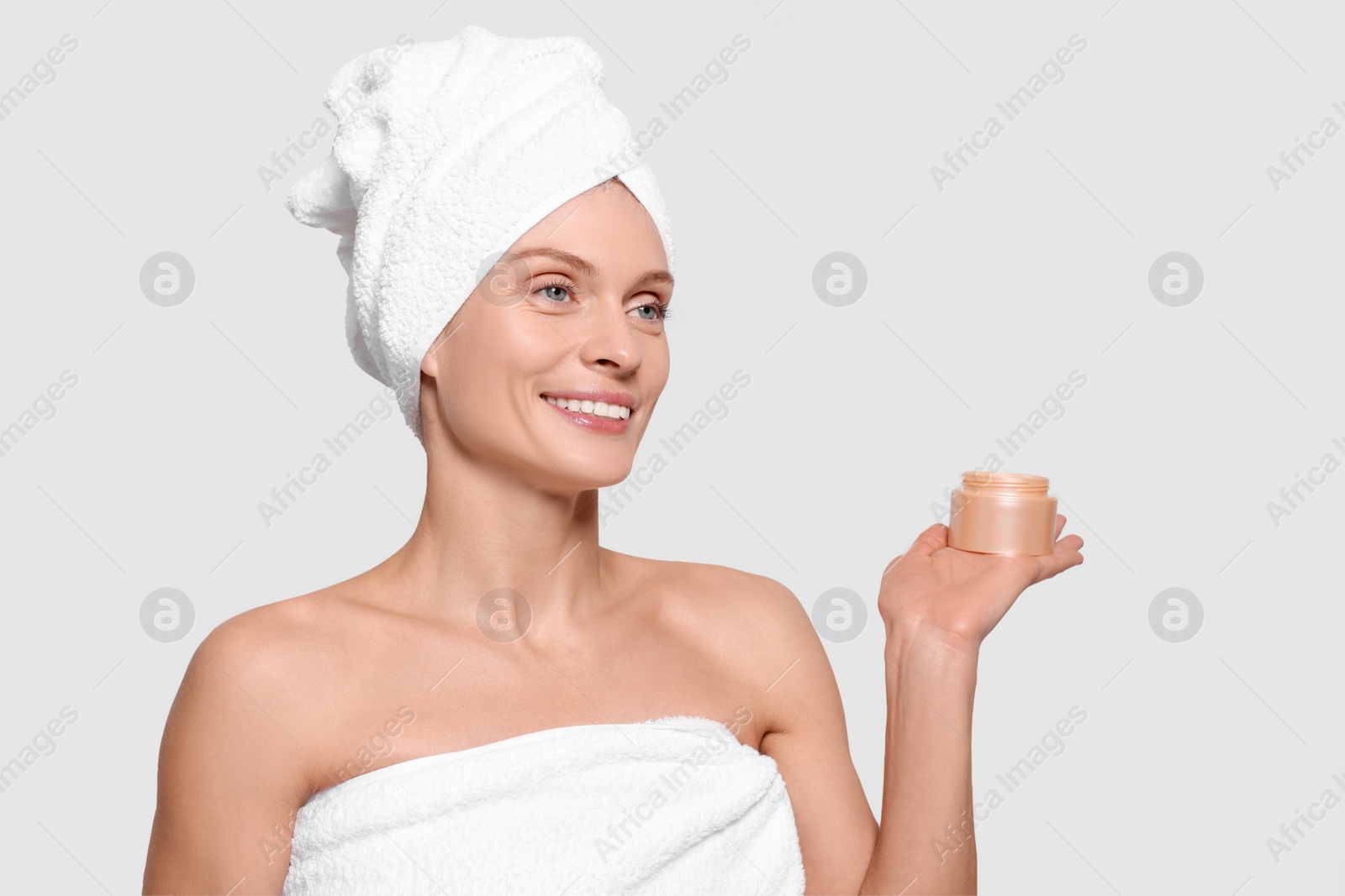 Photo of Woman with jar of body cream on white background