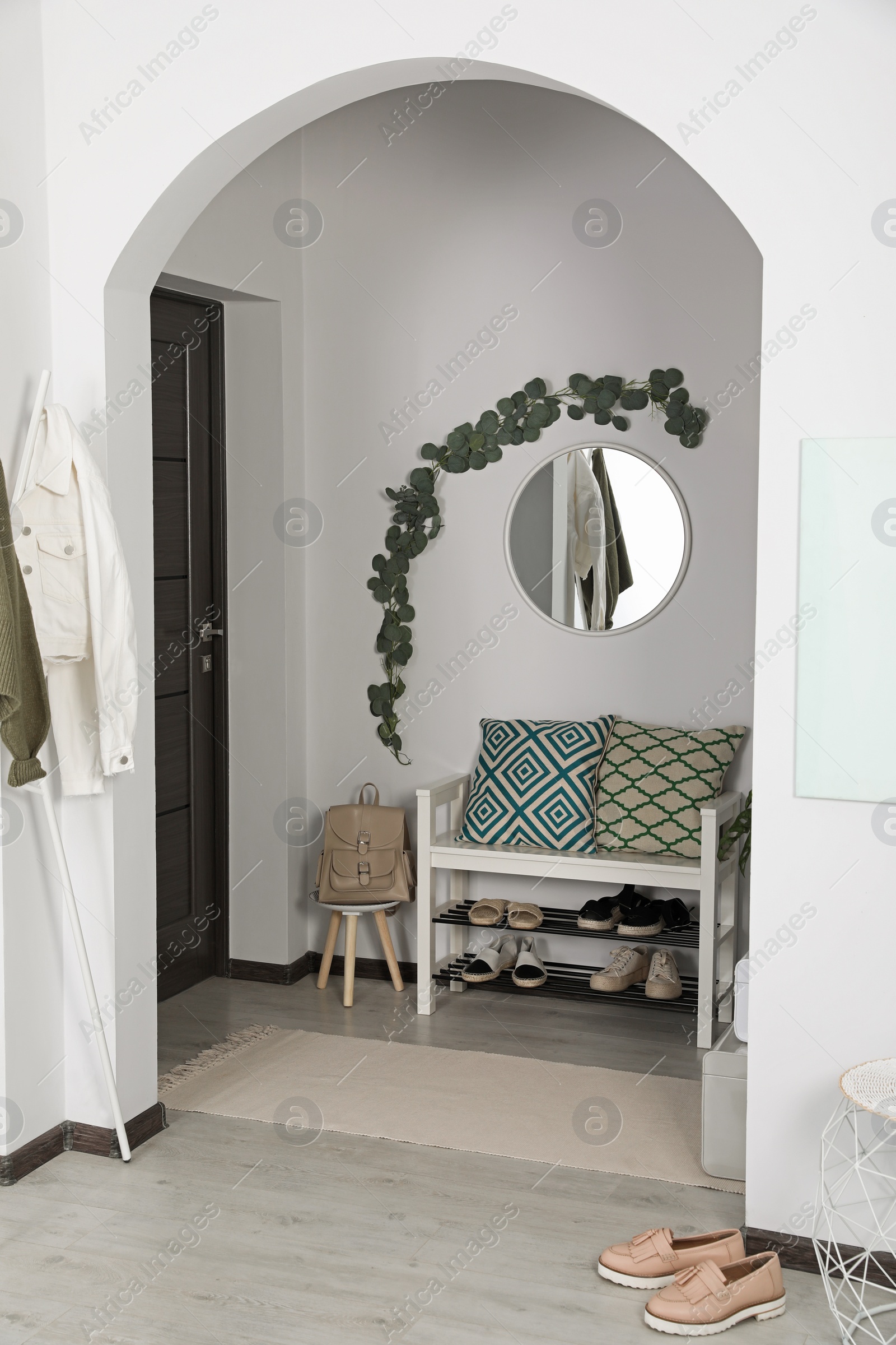 Photo of Hallway interior with stylish furniture and round mirror on light wall