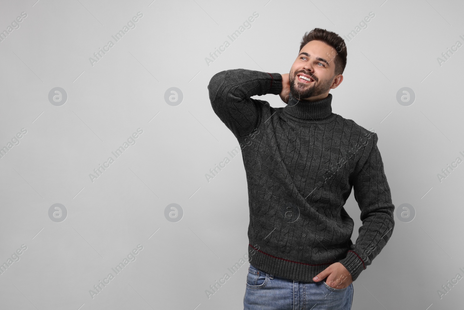 Photo of Happy man in stylish sweater on white background, space for text