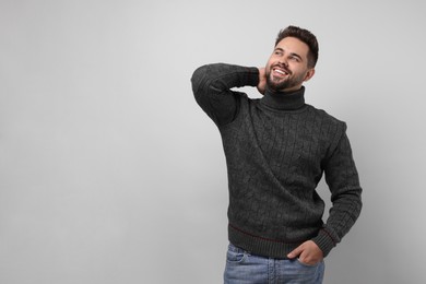 Photo of Happy man in stylish sweater on white background, space for text