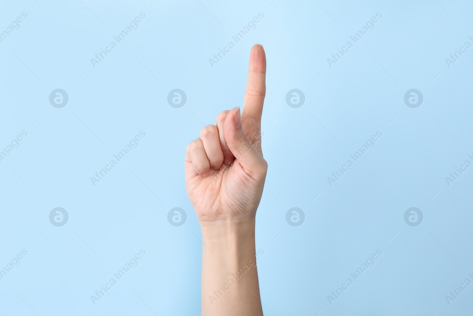 Photo of Woman showing number one on color background, closeup. Sign language