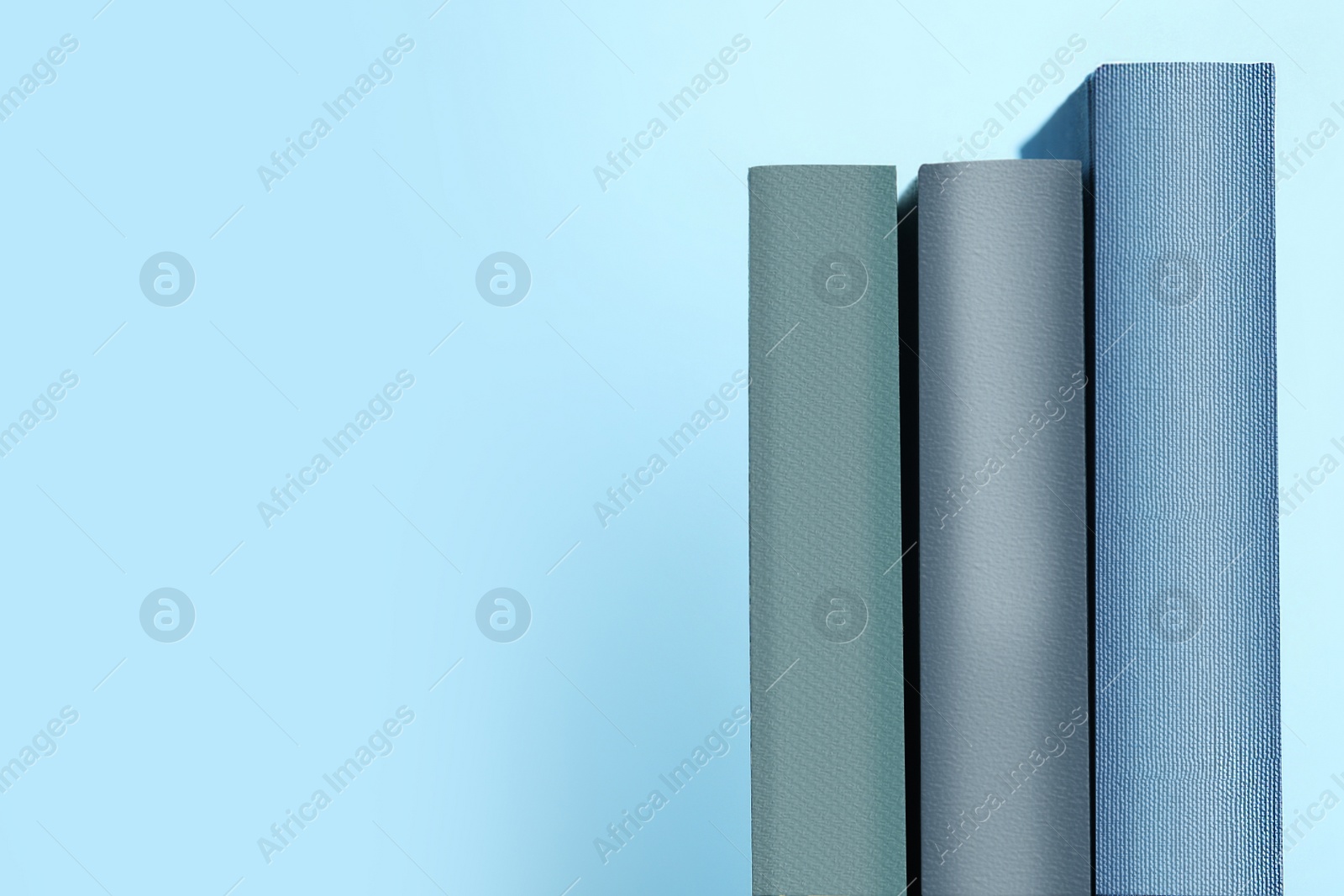 Photo of Old books on light blue background, space for text