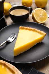 Photo of Slice of delicious homemade lemon pie on wooden table