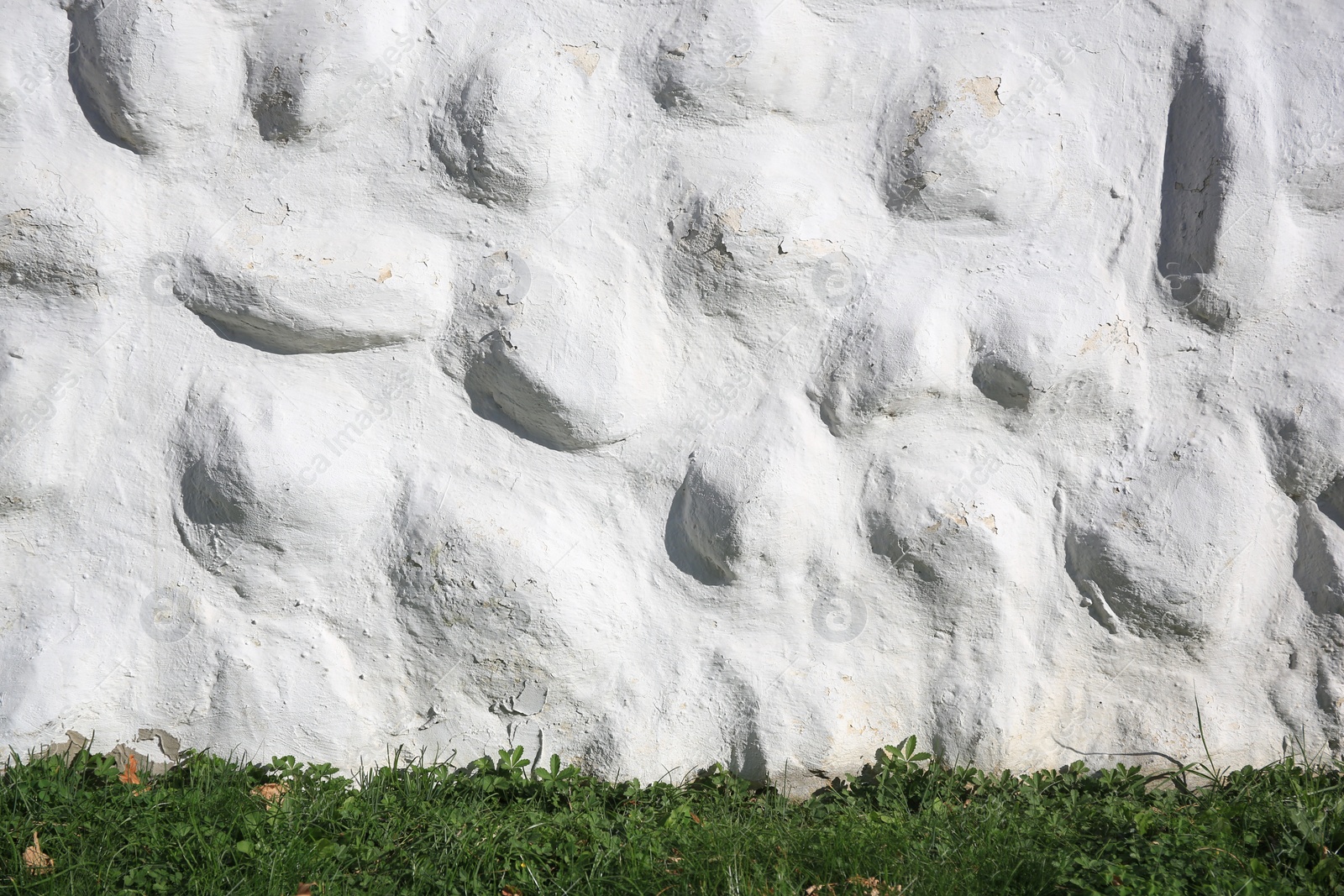 Photo of White stone wall of building near green grass outdoors. Exterior design