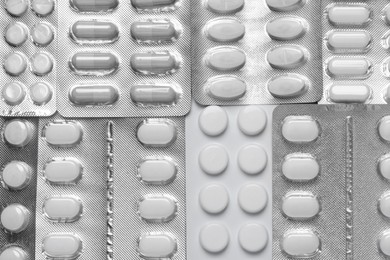 Many different pills in blisters as background, top view