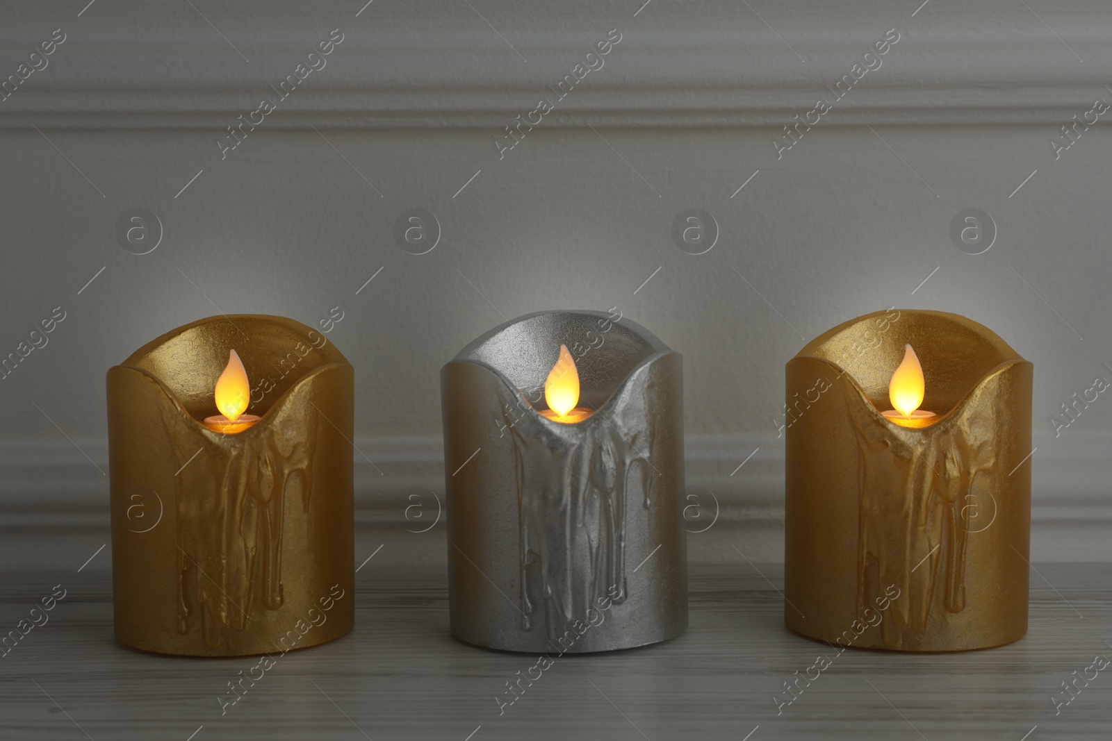 Photo of Glowing decorative LED candles on wooden table