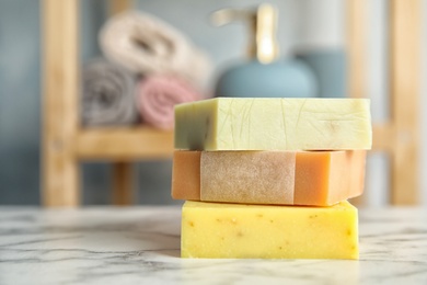 Photo of Stack of different handmade soap bars on table. Space for text