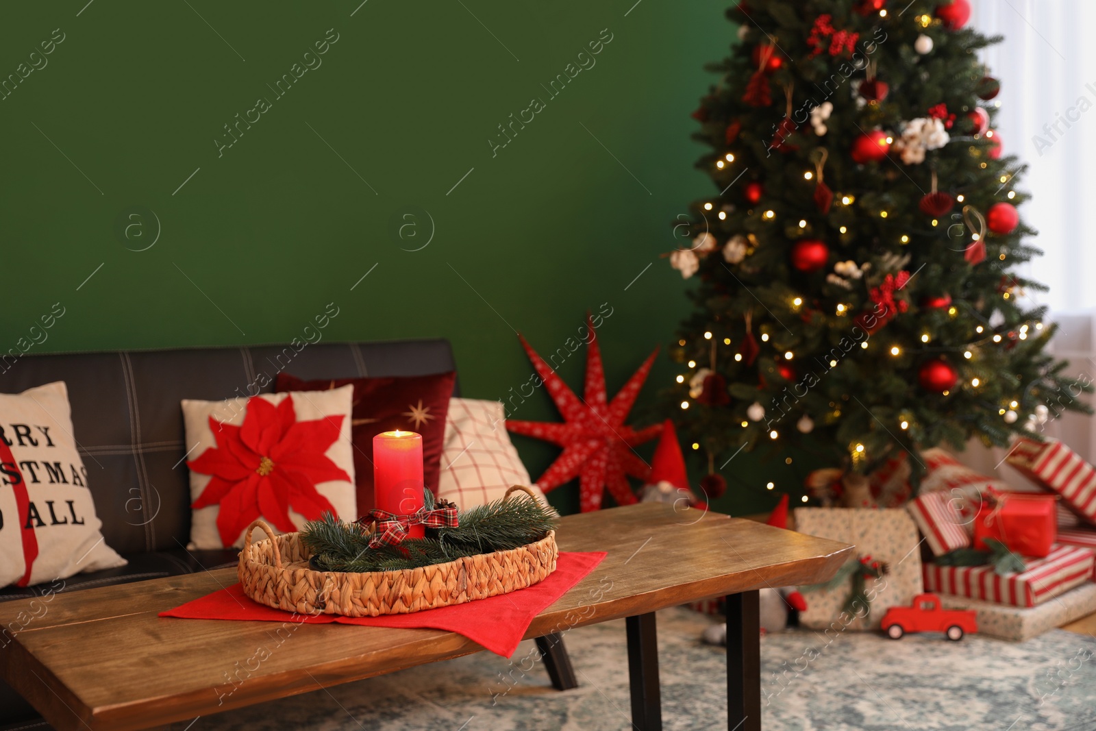 Photo of Wicker tray with red candle and fir branches on wooden table indoors, space for text. Christmas decor