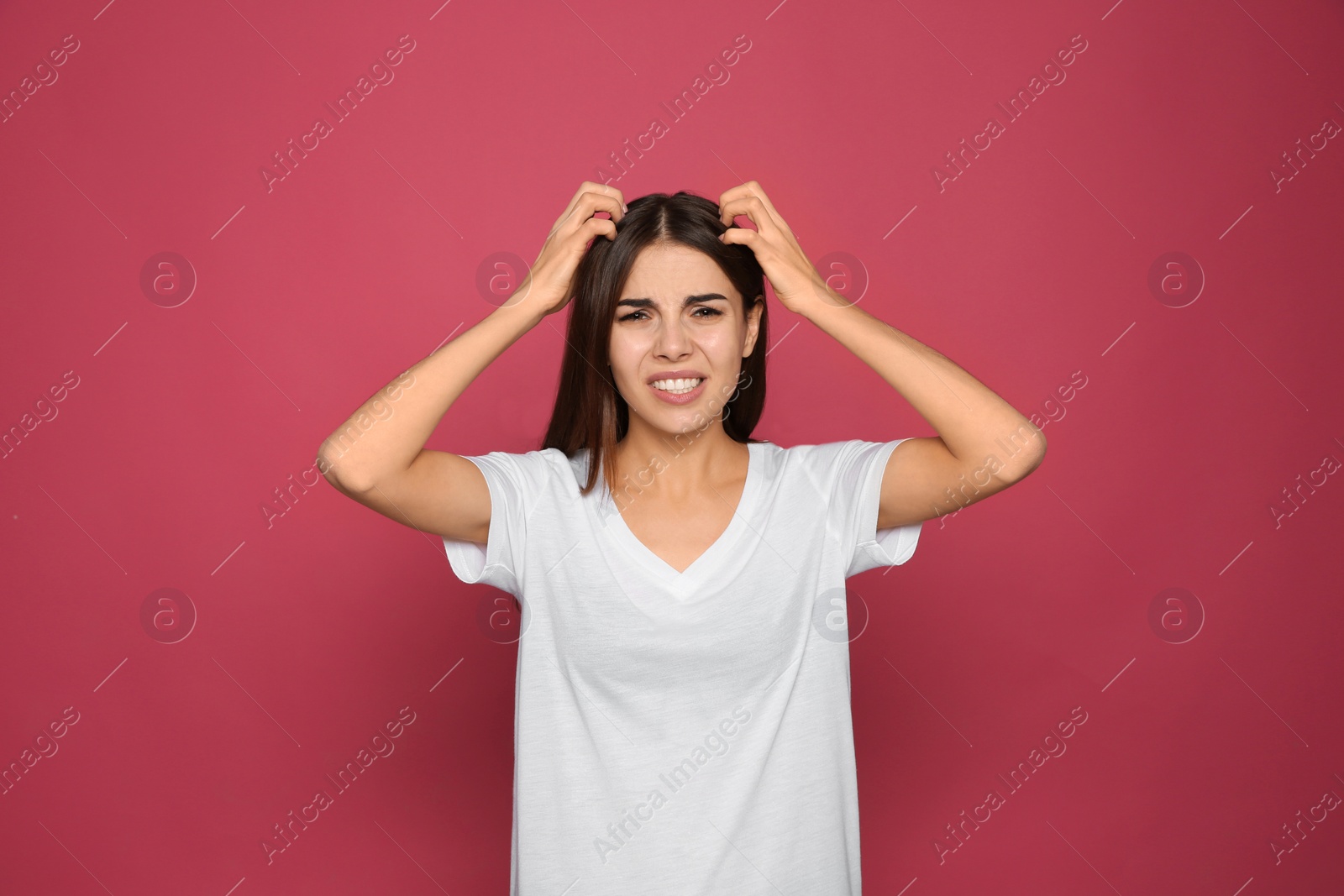 Photo of Young woman scratching head on color background. Annoying itch