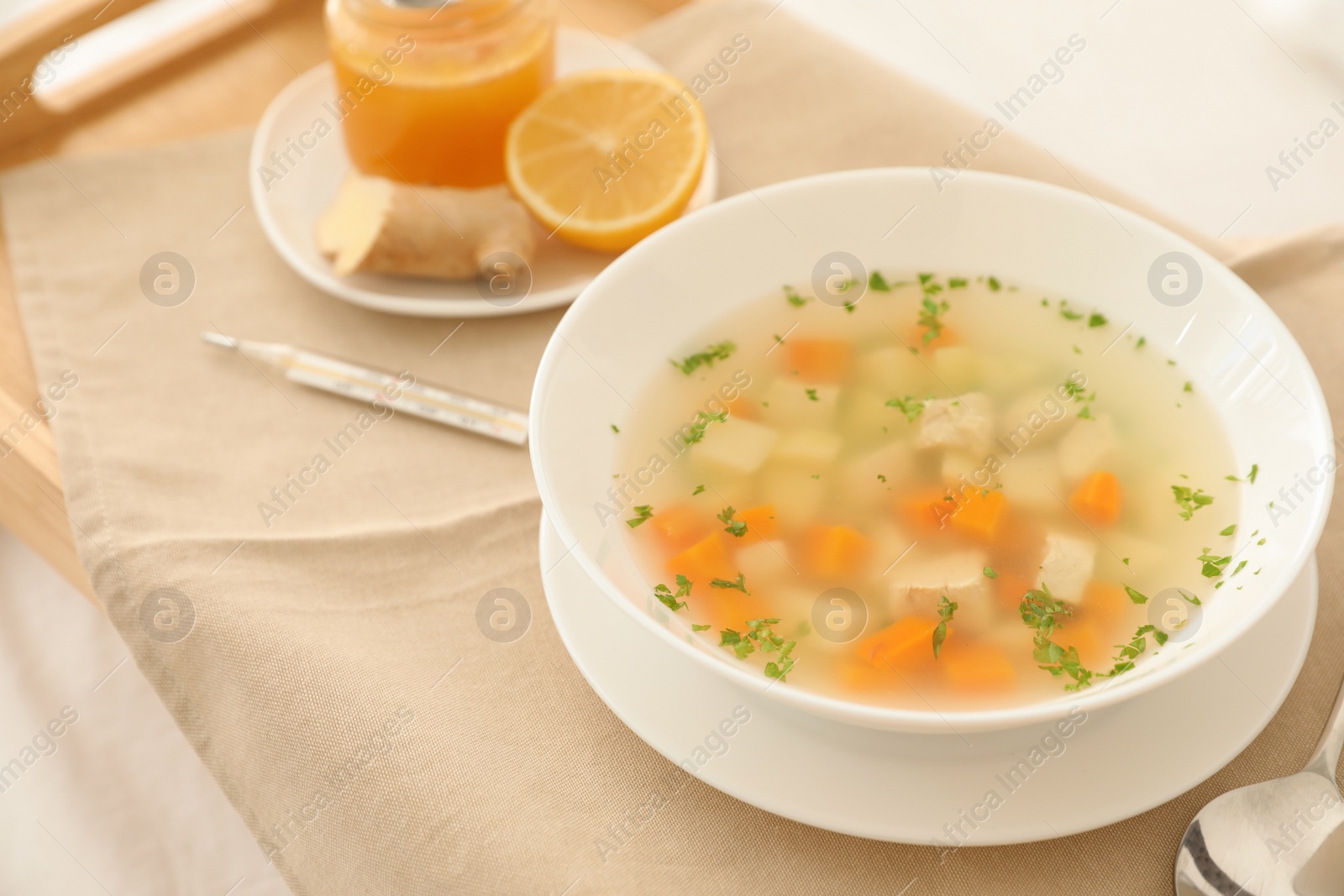 Photo of Bowl of fresh homemade soup to cure flu on tray