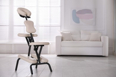 Modern massage chair in office, space for text. Medical equipment