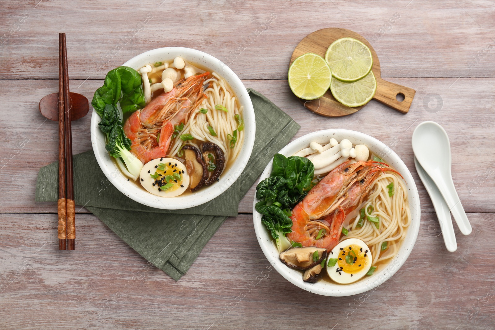 Photo of Delicious ramen with shrimps in bowls served on wooden table, flat lay. Noodle soup