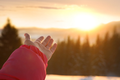Photo of Young woman enjoying beautiful sunset outdoors, closeup view with space for text. Winter vacation