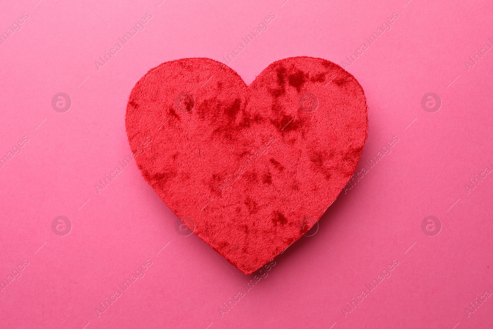 Photo of Red textile heart on pink background, top view