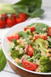 Photo of Healthy meal. Tasty salad with quinoa, chickpeas and vegetables on table, closeup