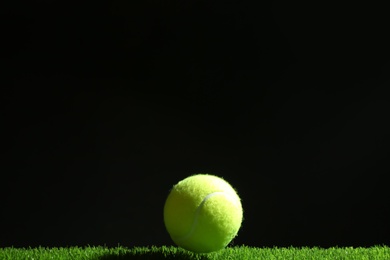 Tennis ball on green grass. Space for text