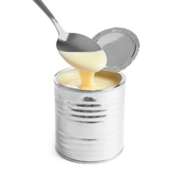 Condensed milk pouring from spoon into tin can on white background. Dairy product