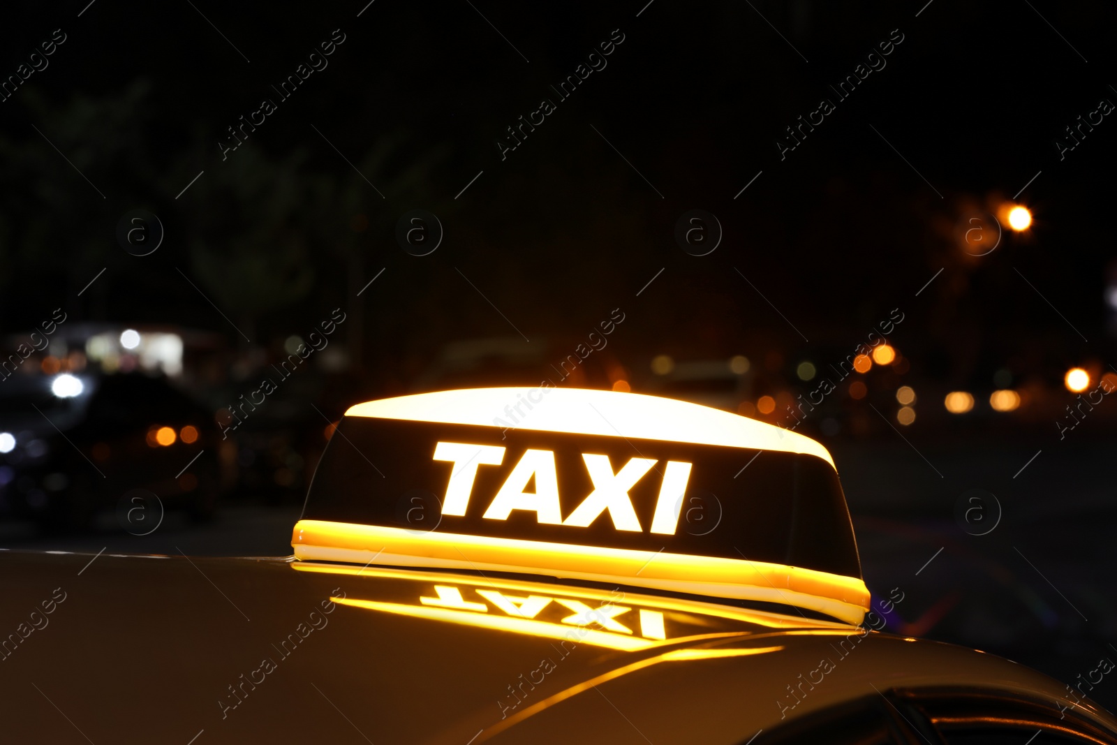 Photo of Taxi car with yellow sign outdoors at night
