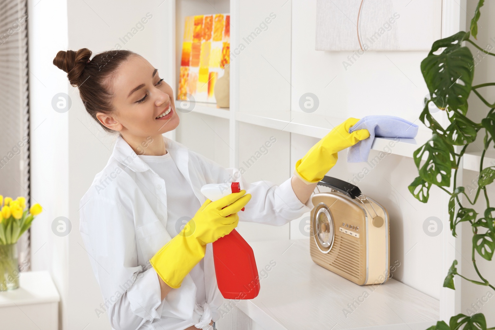 Photo of Spring cleaning. Young woman tidying up room at home