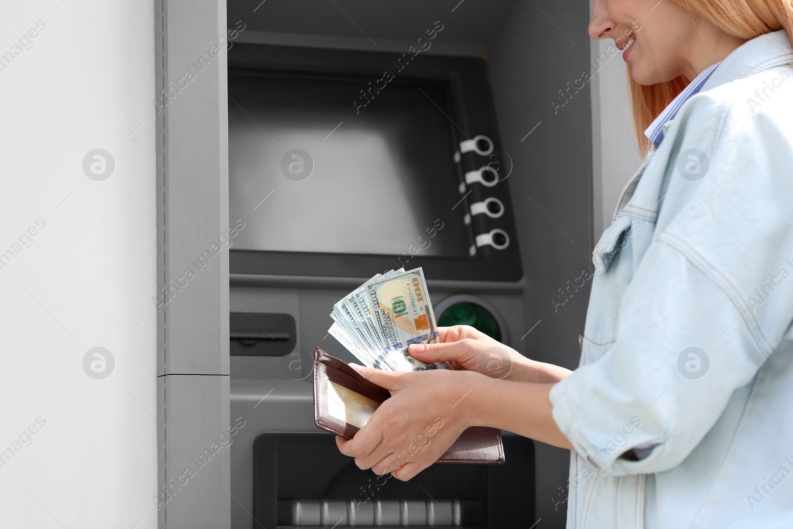 Photo of Woman with money near cash machine outdoors, closeup