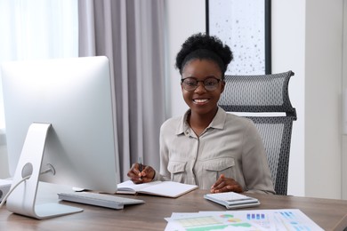 Photo of Professional accountant working on computer at wooden desk in office