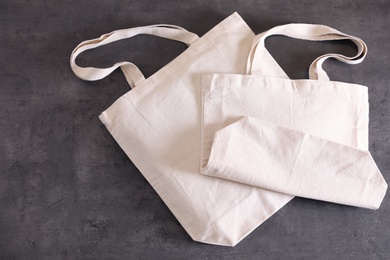Photo of Eco tote bags on grey background, top view