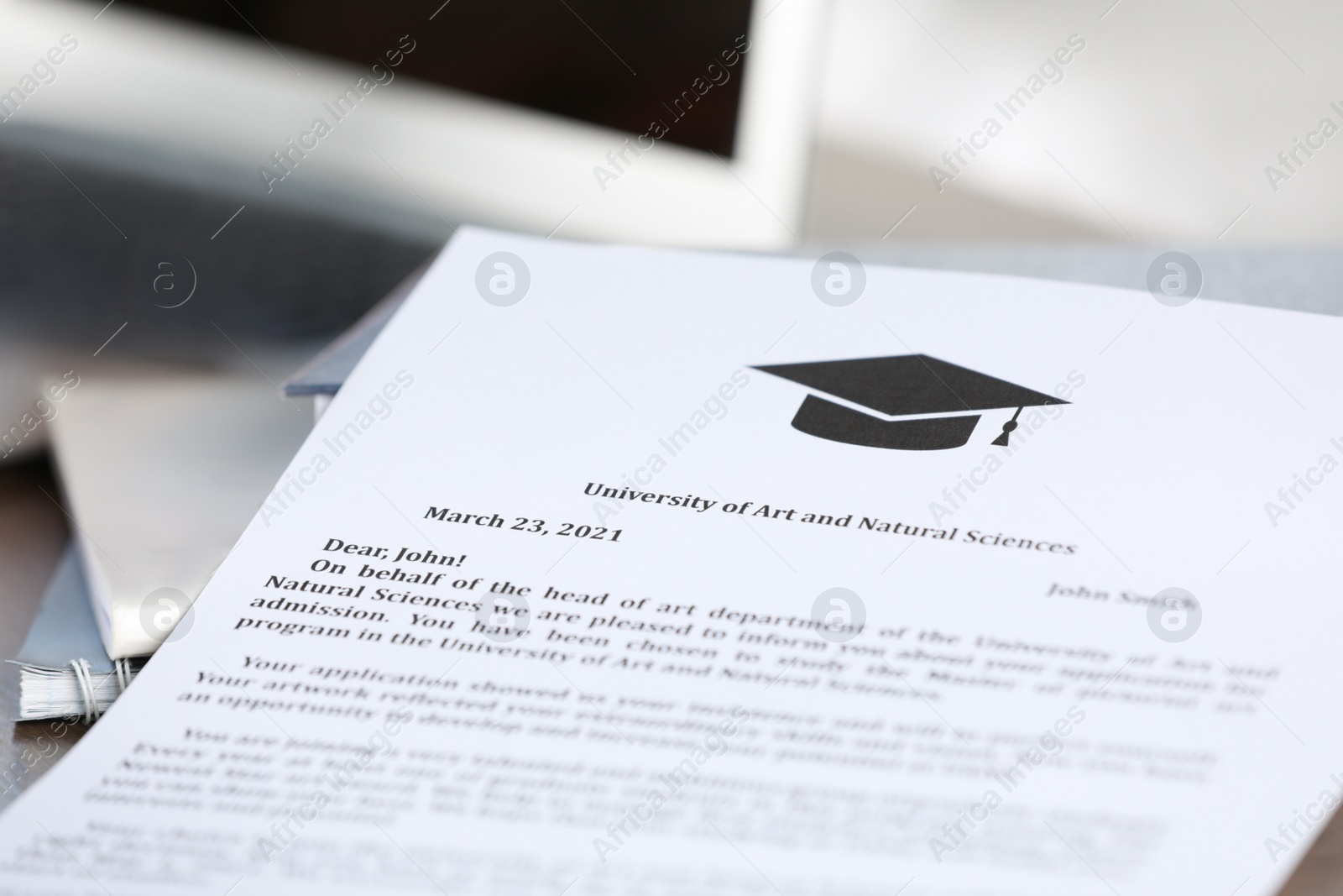 Photo of Acceptance letter from university and books on table, closeup